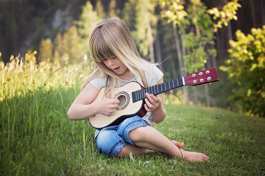 instrumenty-muzyczne-dla-dzieci-dziewczynka-grajaca-na-gitarze